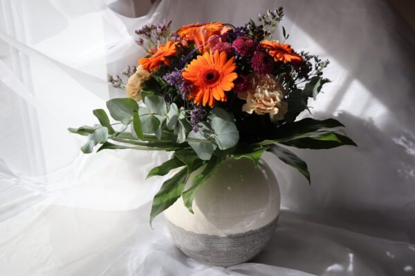 Strauß orange mit Vase und weißem Hintergrund